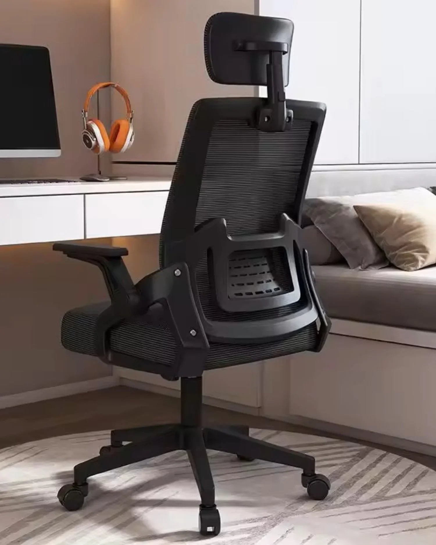 Silla de oficina Ergonomica Essential negra en un escritorio, mostrando su soporte lumbar