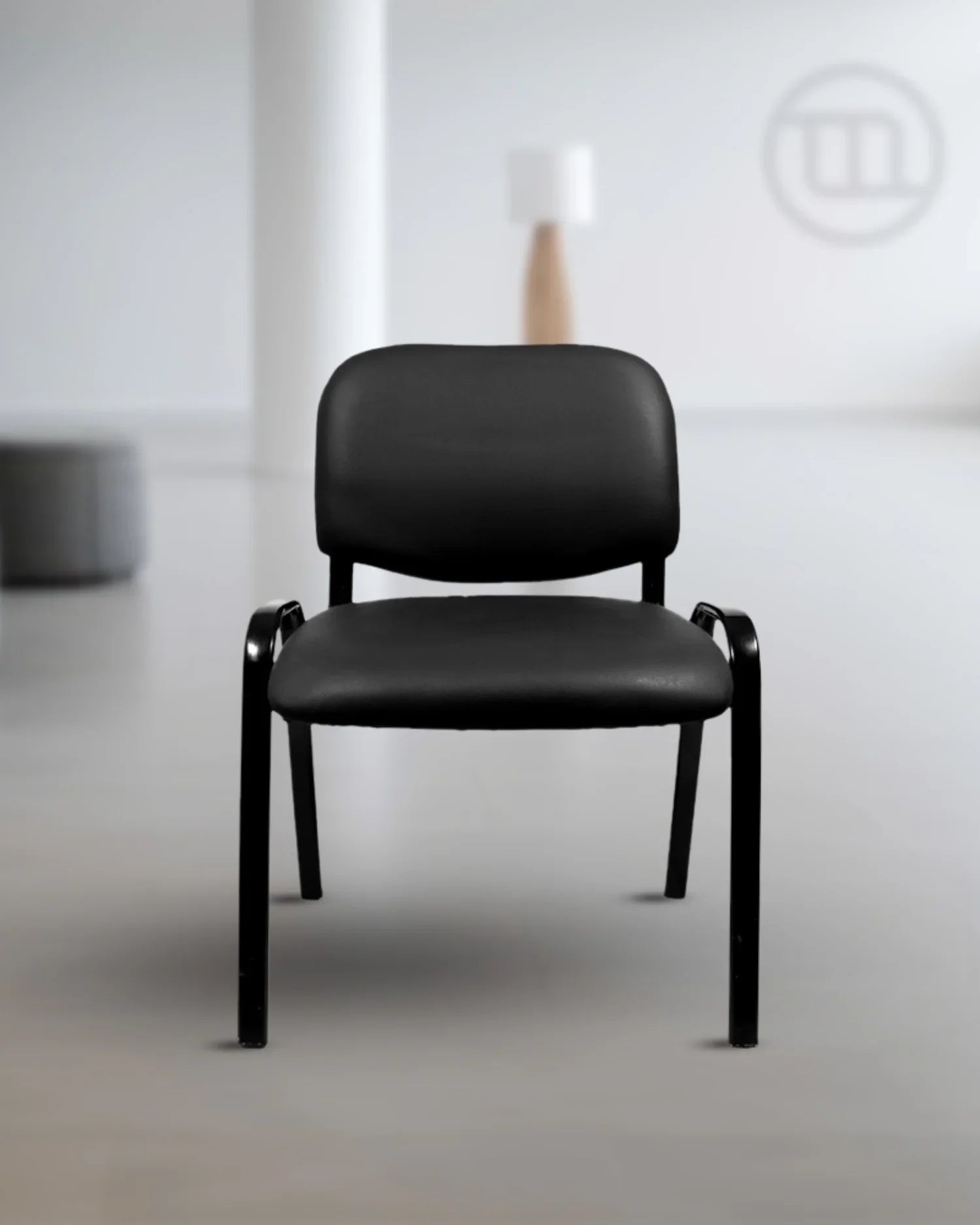 Silla de visita ISO tapizada en ecocuero negro, en una sala de recepción moderna