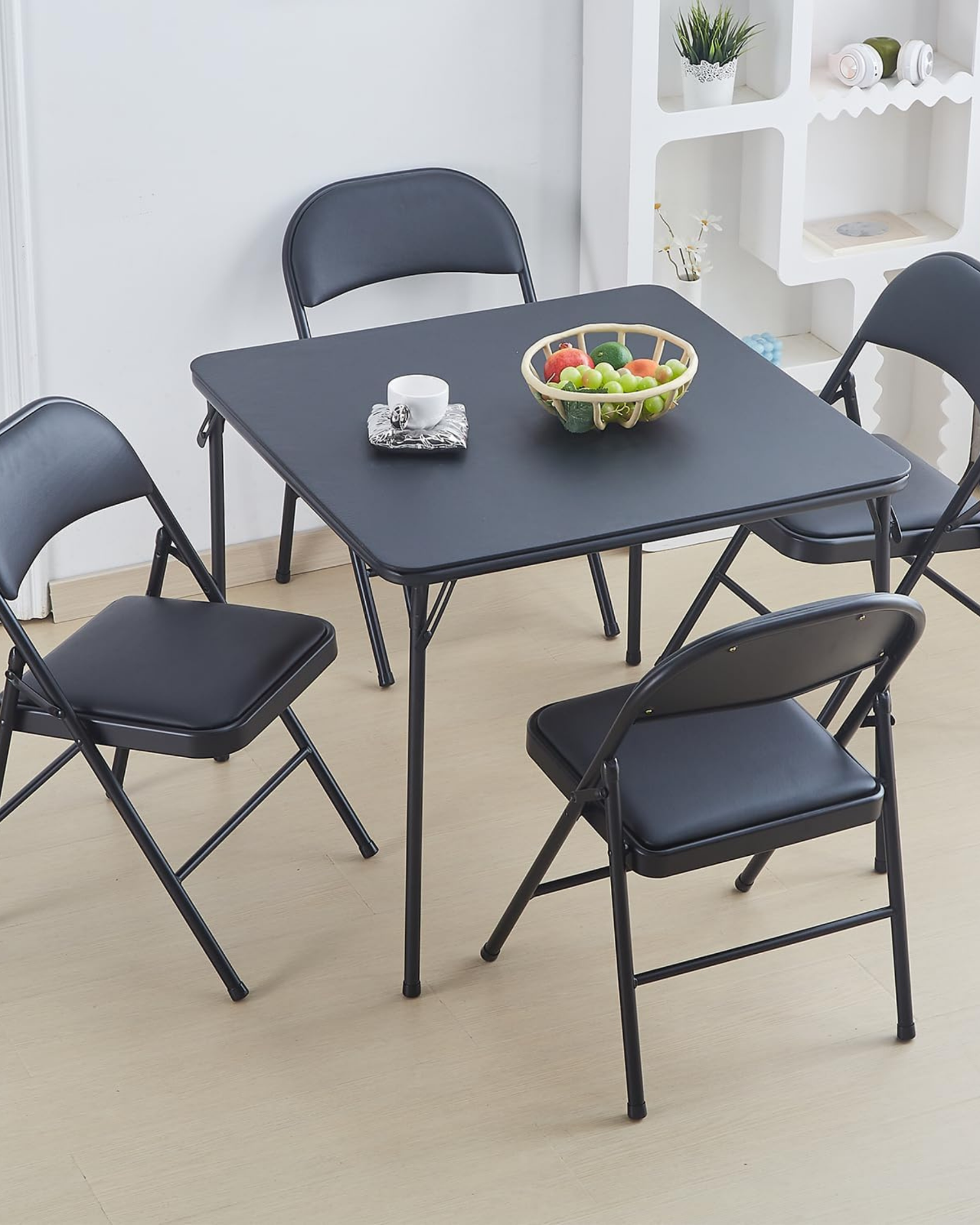 Juego de comedor con mesa y cuatro sillas plegables metálicas negras en uso